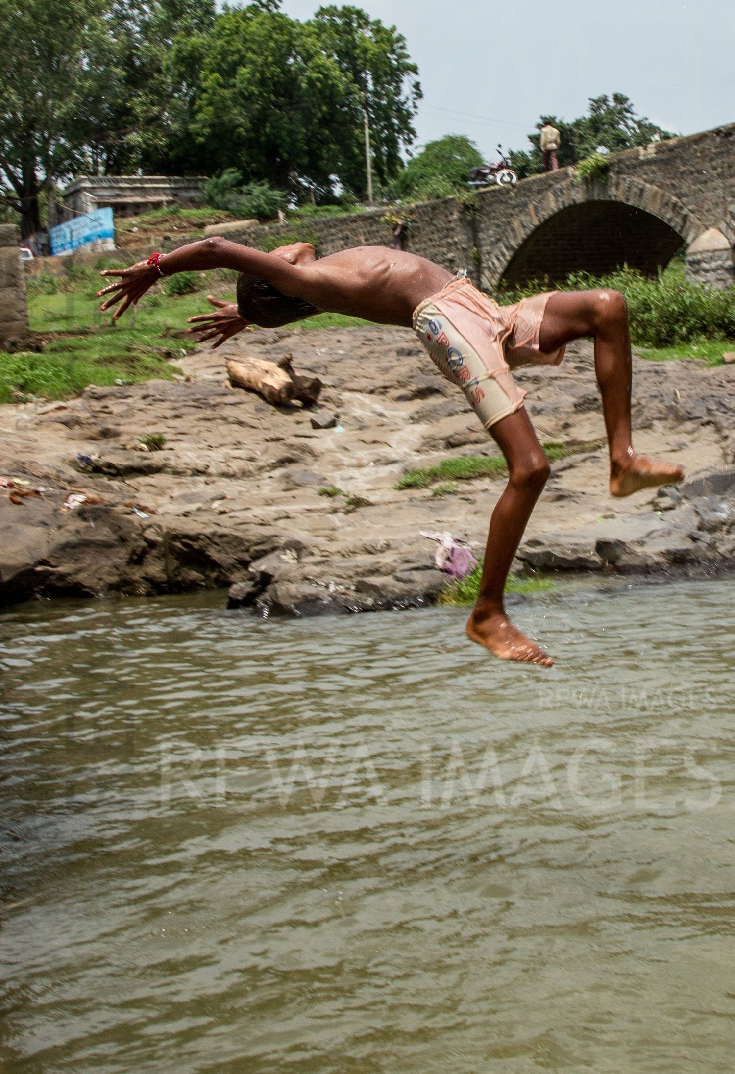 Kids leaping into the river